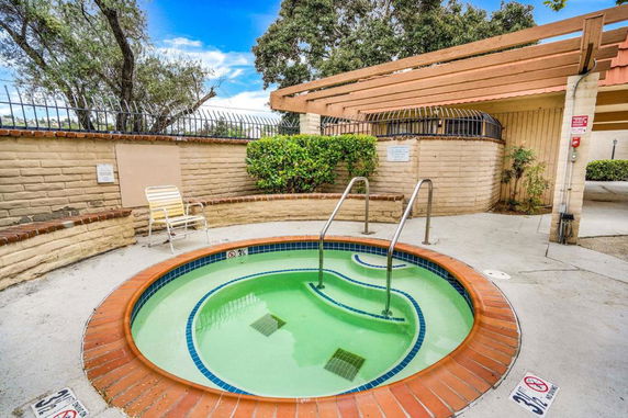 Small outdoor circular pool with steps and a surrounding patio area.