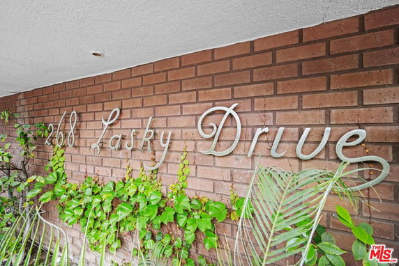 Brick wall with '268 Lasky Drive' signage and greenery.