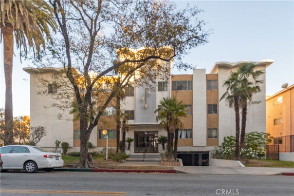Front view of a multi-story apartment building with distinct roof design.