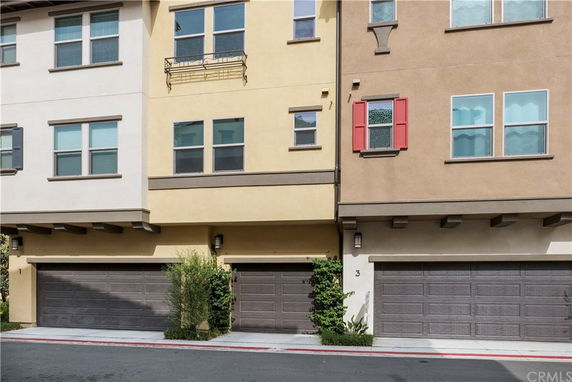 Front view of a multi-story townhouse with garages.