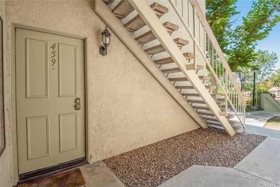 Entry view of a residential building with an outdoor staircase and door labeled 459.