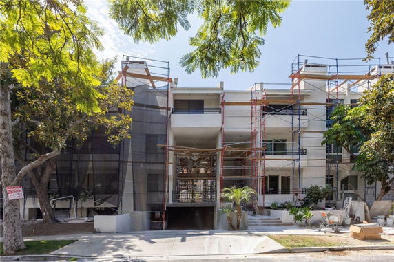 Front view of a multi-story building under construction with scaffolding.