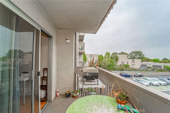 View from an apartment balcony overlooking a parking area.