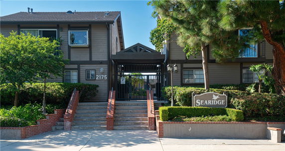 Front view of a residential building with a gated entrance and sign reading 'Searidge'.