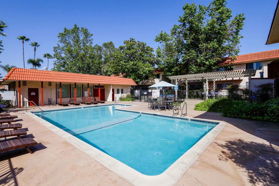 Outdoor swimming pool area with surrounding buildings.