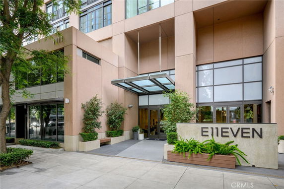 Front view of a modern building with glass entrance and signage.