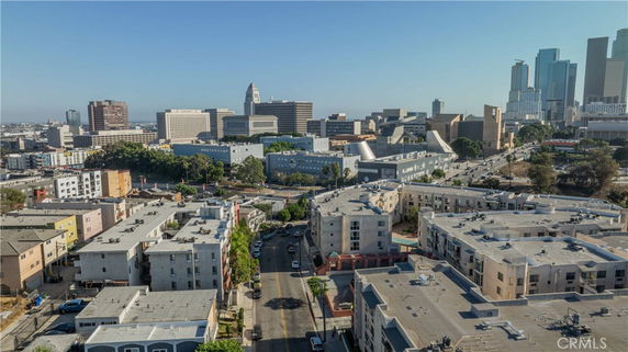 Aerial view of residential and commercial buildings in a city with a skyline in the background.