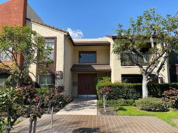 Front view of a two-story house with a brown roof and large windows.