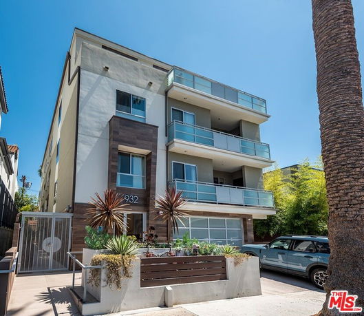 Front view of a multi-story modern apartment building with balconies.
