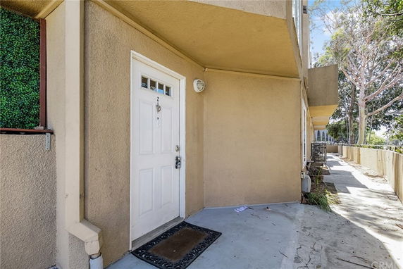Entrance view of a building with beige exterior walls and a white door.
