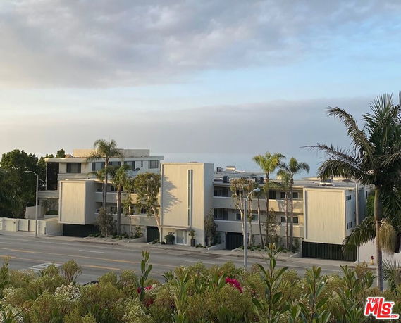 Front view of a multi-story residential complex with modern architecture.
