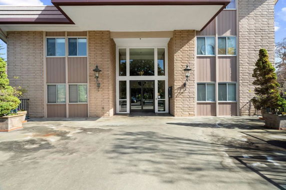 Front view of a building with large glass entrance and brick facade.