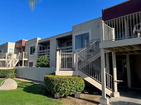 Front view of a multi-story apartment building with exterior staircases.