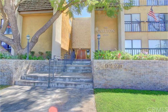 Front view of a multi-story building with a staircase leading to the entrance.
