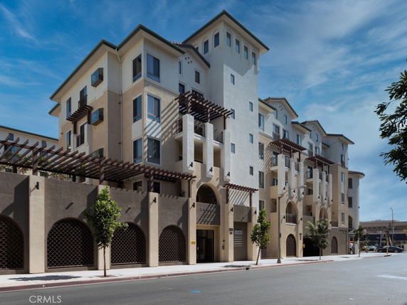 Front view of a multi-story residential building with balconies and decorative elements.