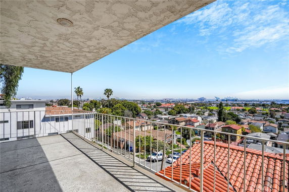 Panoramic view of a residential area with distant cityscape and industrial structures.