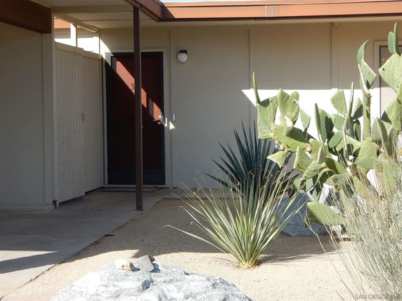 Front view of a house entrance with a flat roof and a small porch area.