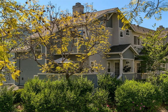 Front view of a two-story house with a porch and multiple windows.