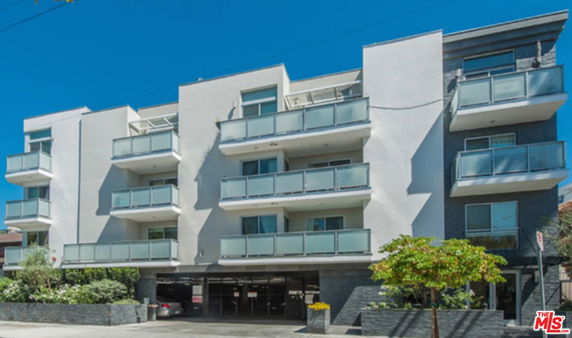 Front view of a modern multi-story apartment building with balconies.