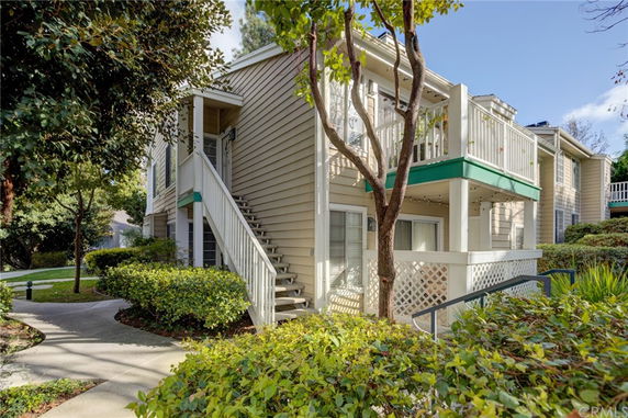 Front view of a two-story residential building with an external staircase.