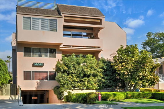 Front view of a multi-story building with a parking entrance.