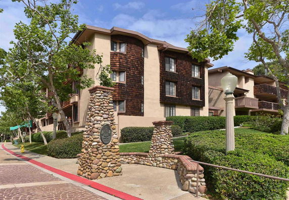 Front view of a multi-story apartment building with stone pillars at the entrance.