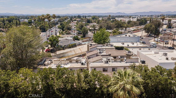 Aerial view of a neighborhood with residential buildings surrounded by trees and streets.