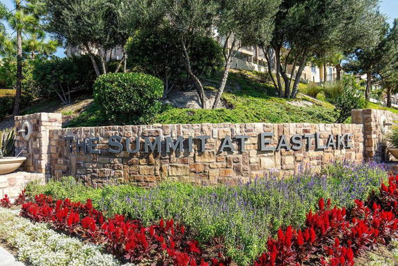 Stone sign with 'The Summit at Eastlake' surrounded by landscaped plants.