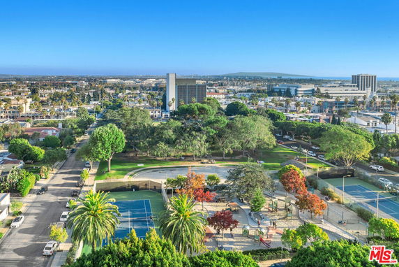 View from building showing surrounding cityscape, park, and tennis courts.