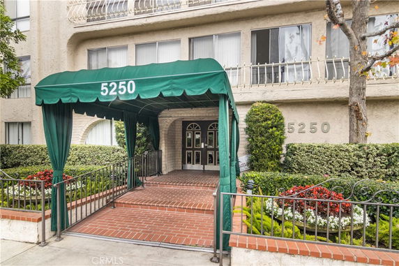 Front view of a building with a green awning and number 5250 displayed.
