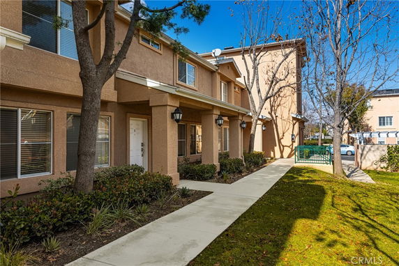 Front view of a two-story building with beige stucco exterior and white trim.