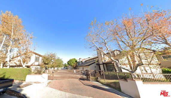 Front view of gated residential area with multi-story houses.