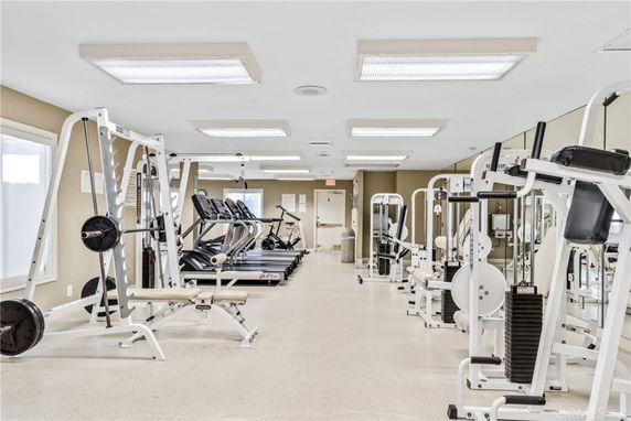 Indoor gym area with various exercise equipment including treadmills and weightlifting machines.