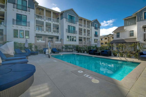 View of a building exterior with a swimming pool in the foreground.