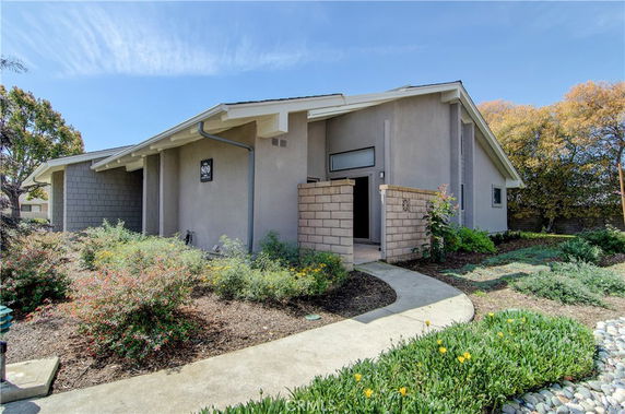 Front view of a modern single-story house with a paved walkway.