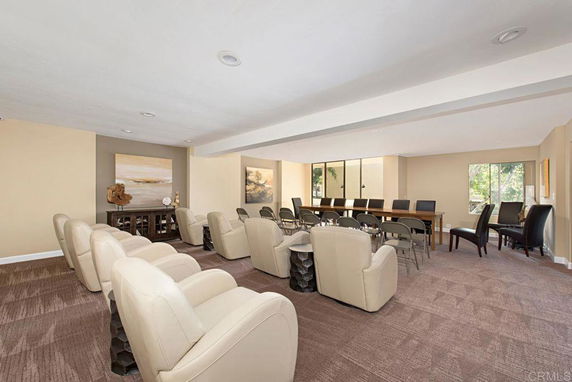 Indoor recreational room with seating and tables arranged for activities.
