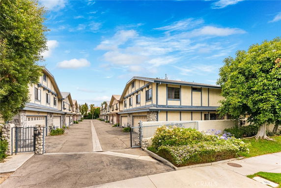 Front view of a row of two-story townhouses with garages.