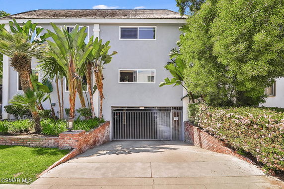 Front view of a multi-story house with a gated entrance.
