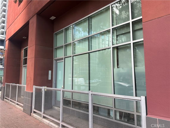 Front view of a modern building with large windows and a red facade.