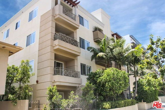 Front view of a multi-story apartment building with balconies.