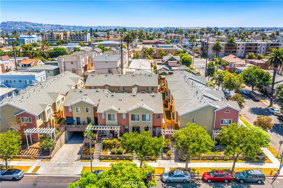 Aerial view of a row of townhouse-style buildings with multiple stories and gabled roofs.