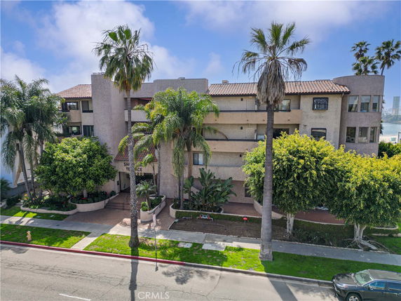 Front view of a multi-story apartment building with a Mediterranean design.