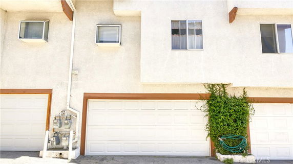 Front view of a building with double garage doors and windows above.