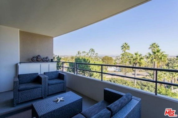 Outdoor seating area with a view of trees and distant landscape.