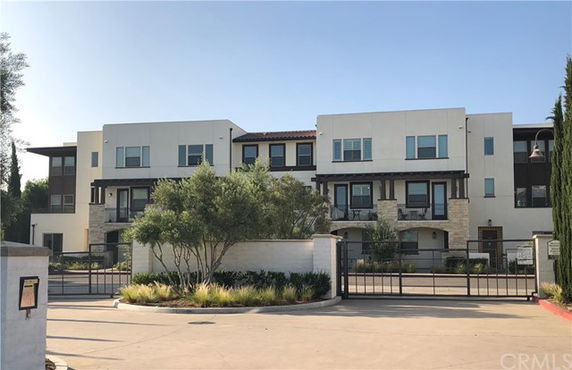 Front view of a multi-story building with gated entrance.