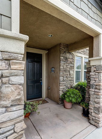 Front entrance of a house with stone and stucco design.