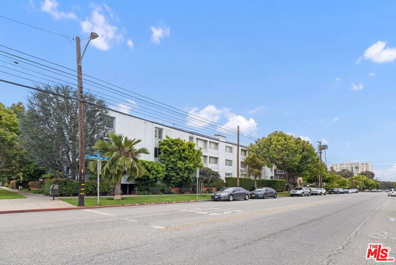 Front view of a multi-story apartment building on a street.