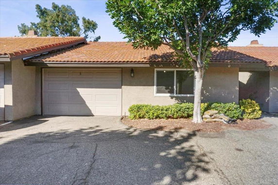 Front view of a single-story house with a garage and a tiled roof.