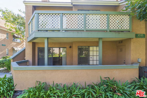 Front view of a two-story house with a balcony and railing.