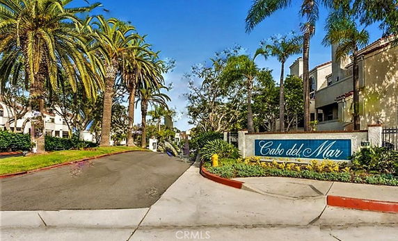 Entrance view with sign of Cabo del Mar and palm trees.